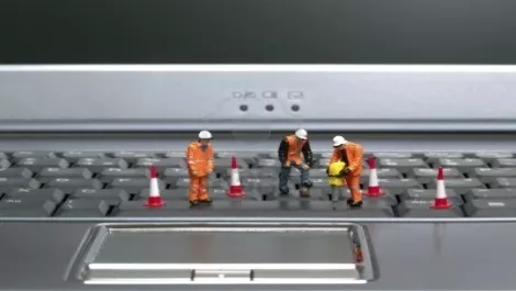 3316805 miniature workmen repairing a laptop keyboard